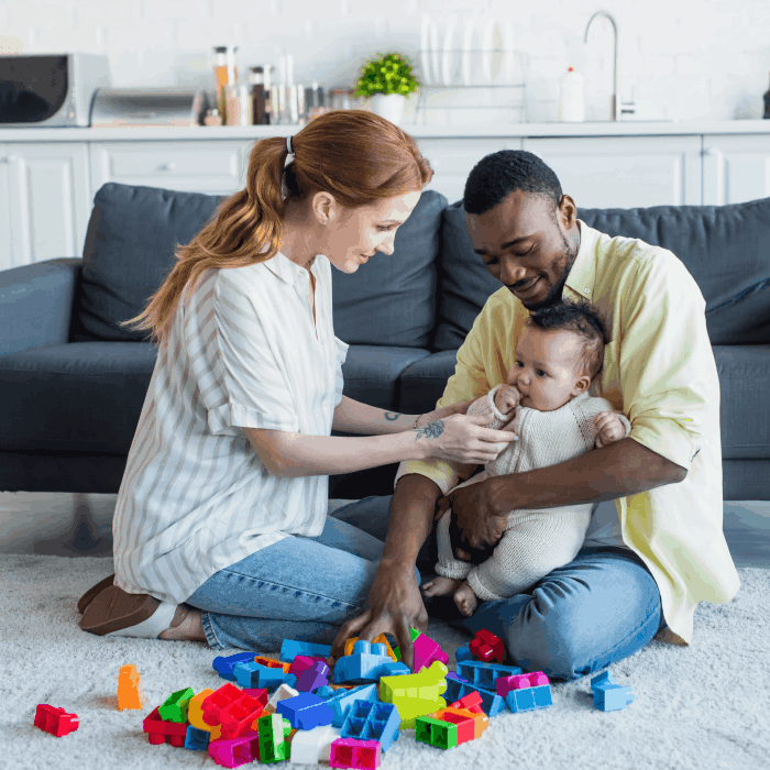 A mother and father playing with their baby.