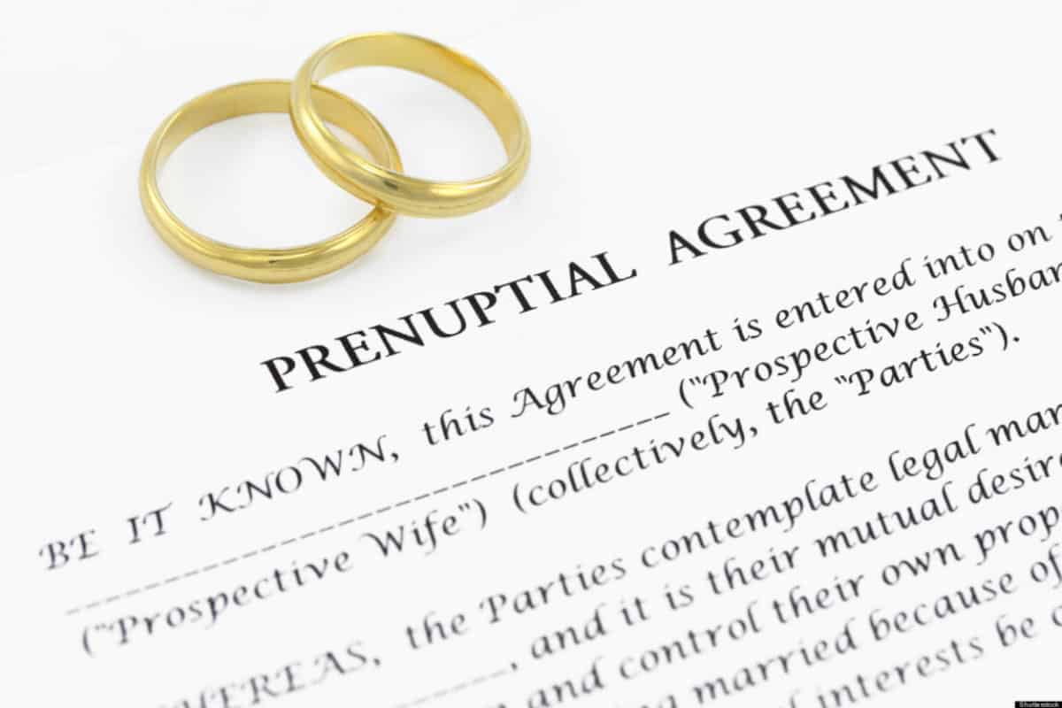 Prenuptial Agreement Document with two rings on top of it